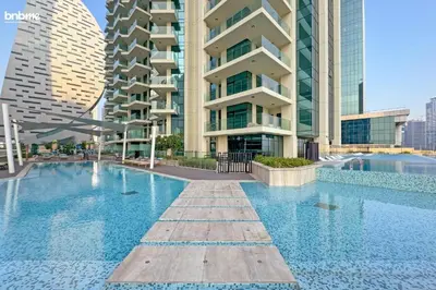 a swimming pool in front of a large building at Elite apartment near Dubai Mall in Dubai