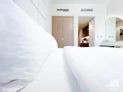 a bedroom with white walls and white furniture at Luxury Living in Azizi Riviera l Cozy Balcony in Dubai