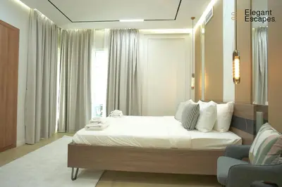a bedroom with a large white bed and a chair at Stylish 1B in Heart of Marina Near Attractions in Dubai