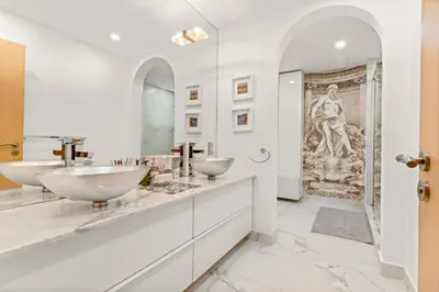 a white bathroom with two sinks and a shower at VayK - Stunning 2BR with Sea View & Beach Access in Dubai
