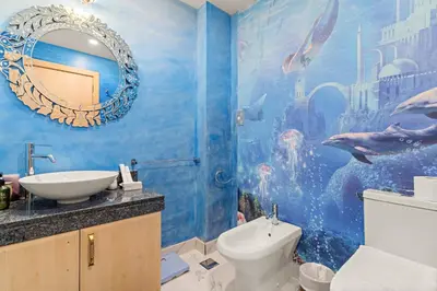 a bathroom with a blue wall with a fish mural at VayK - Stunning 2BR with Sea View & Beach Access in Dubai