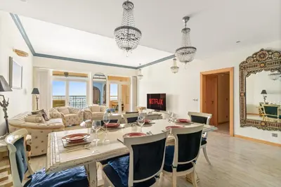 a dining room and living room with a table and chairs at VayK - Stunning 2BR with Sea View & Beach Access in Dubai