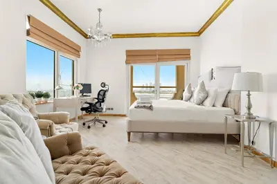 a white bedroom with a bed and a desk at VayK - Stunning 2BR with Sea View & Beach Access in Dubai