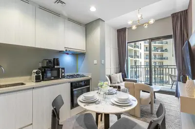 a kitchen and living room with a table and chairs at Sleek 1-Bedroom Getaway in Zada Tower in Dubai