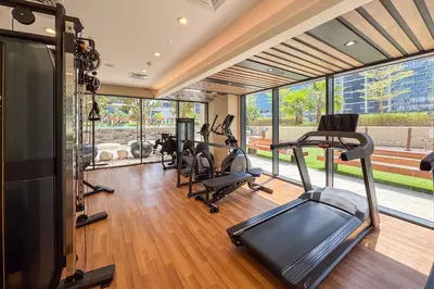 a gym with treadmills and ellipticals in a room with windows at Sleek 1-Bedroom Getaway in Zada Tower in Dubai
