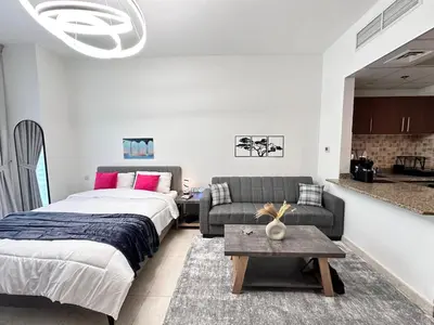 a bedroom with a bed and a couch at Enjoy our feel-home Appartement in Dubai