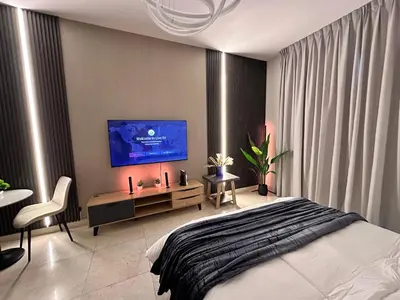 a bedroom with a bed and a tv on a wall at Enjoy our feel-home Appartement in Dubai