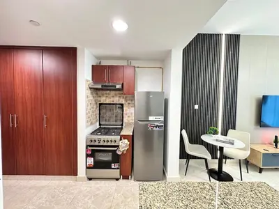 a kitchen with a stainless steel refrigerator and a table at Enjoy our feel-home Appartement in Dubai