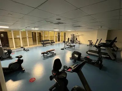 a gym with several treadmills and exercise bikes at Enjoy our feel-home Appartement in Dubai