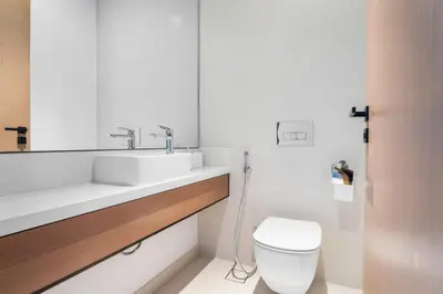a white bathroom with a sink and a toilet at VayK - Sleek & Stylish 1BR in Vida Dubai Marina in Dubai