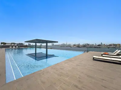 a swimming pool with a pavilion on top of a building at Vayk - Bright & Elegant 2BR Apartment with Creek Views in Dubai
