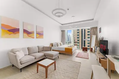 a living room with a couch and a tv at VayK - Comfortable Studio in JLT with Amazing Amenities in Dubai