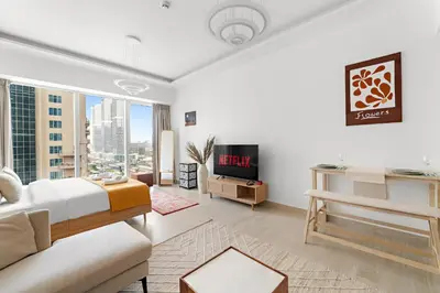 a bedroom with a bed and a couch and a tv at VayK - Comfortable Studio in JLT with Amazing Amenities in Dubai
