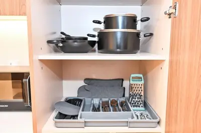 a kitchen with two pots and pans on a shelf at Golden Stays - Brand New JVC Studio I Modern & Fully Furnished in Dubai