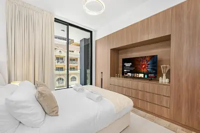 a bedroom with a large bed with a flat screen tv at Golden Stays - Brand New JVC Studio I Modern & Fully Furnished in Dubai