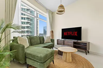 a living room with a couch and a tv at VayK - Modern 1BR apartment in the Heart of Downtown Dubai in Dubai
