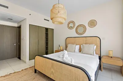 a bedroom with a large bed with white sheets at VayK - Modern 1BR apartment in the Heart of Downtown Dubai in Dubai