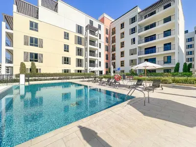 a swimming pool in front of a building at VayK - Modern 2BR with Stunning Sea View in Port de La Mer in Dubai
