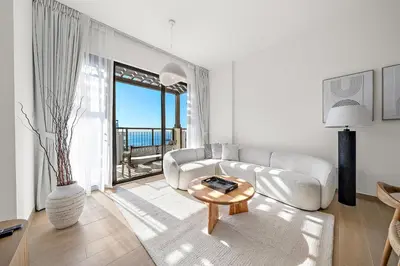 a living room with a couch and a table at VayK - Modern 2BR with Stunning Sea View in Port de La Mer in Dubai