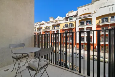 a balcony with a table and chairs and a building at VayK - Contemporary and Cozy Studio in the Heart of JVC in Dubai