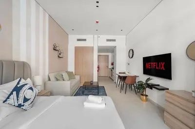 a bedroom with a bed and a living room at VayK - Contemporary and Cozy Studio in the Heart of JVC in Dubai