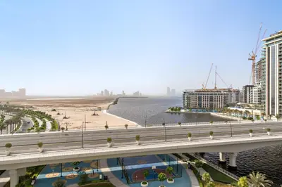 a bridge over a river with a beach and buildings at VayK - Stunning 1BR with Breathtaking Views in Dubai