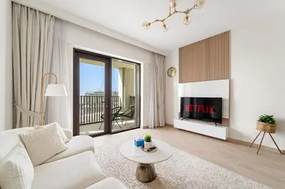 a living room with a white couch and a tv at VayK - Stunning 1BR with Breathtaking Views in Dubai