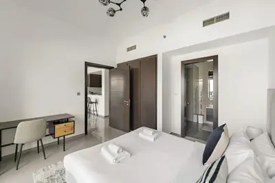 a white bedroom with a white bed and a desk at VayK - Modern 1BR Apartment in Business Bay in Dubai