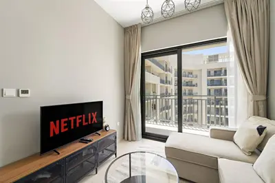 a living room with a couch and a tv and a window at VayK - Stylish 1BR in Business Bay in Dubai