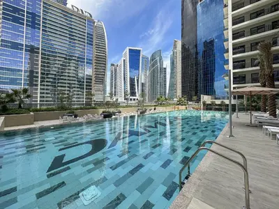 a large swimming pool in a city with tall buildings at VayK - Stylish 1BR in Business Bay in Dubai