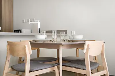 a dining room table with two chairs and a table with glasses at VayK - Ocean View 1BR in the Heart of Dubai Marina in Dubai