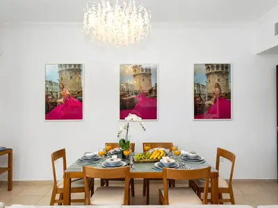 a dining room with a table and a chandelier at Premium One-Bedroom Apartment with Spectacular Marina View & Private Balcony by Dejaview Stays in Dubai