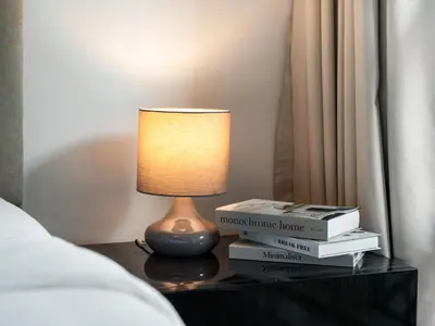 a lamp sitting on a table with books on it at Premium One-Bedroom Apartment with Spectacular Marina View & Private Balcony by Dejaview Stays in Dubai