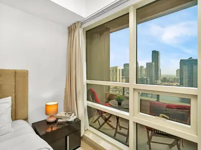 a bedroom with a large window with a view of the city at Premium One-Bedroom Apartment with Spectacular Marina View & Private Balcony by Dejaview Stays in Dubai