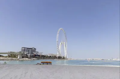 a view of a ferris wheel on the beach at Premium One-Bedroom Apartment with Spectacular Marina View & Private Balcony by Dejaview Stays in Dubai