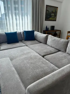 a large gray couch with blue pillows on it at Premium One-Bedroom Apartment with Spectacular Marina View & Private Balcony by Dejaview Stays in Dubai