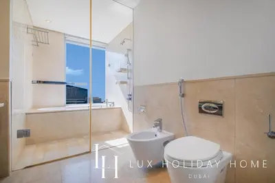a bathroom with a shower and a toilet and a tub at LUX The JW Marina Suite 3 in Dubai