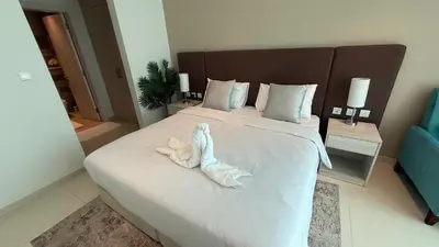 a bedroom with a bed with a stuffed animal on it at Highend Seven Palm 1BR Private Beach and Infinity Pool in Dubai