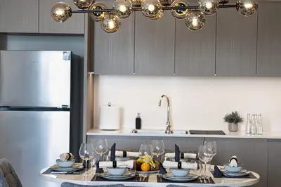 a kitchen with a table with wine glasses on it at SkyHigh Luxury 2BR Burj View Private Hot Tub Walk to DubaiMall in Dubai