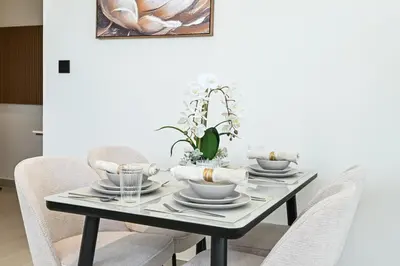 a dining room table with a black table and chairs at Stunning 2BDR Luxury Private Pool and Terrace in Dubai