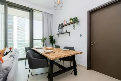 a dining room with a table and a couch at Elite Escape Holiday Home - 1 BHK Getaway with Dubai Mall Access - 3310 in Dubai