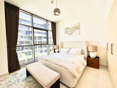 a bedroom with a large bed and a large window at Bright & Airy 2BR Full Park View in Dubai