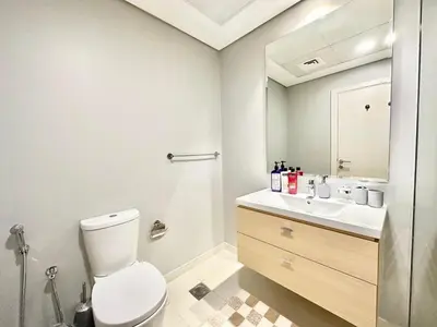 a white bathroom with a toilet and a sink at Bright & Airy 2BR Full Park View in Dubai