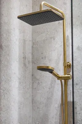 a shower with a gold shower head in a bathroom at Cozy Apartment Gym Pool High 17th Floor JVC Gateway to Dubai in Dubai