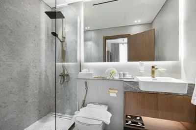 a bathroom with a toilet and a sink and a mirror at Cozy Apartment Gym Pool High 17th Floor JVC Gateway to Dubai in Dubai