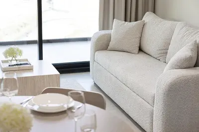 a living room with a couch and a table at Cozy Apartment Gym Pool High 17th Floor JVC Gateway to Dubai in Dubai