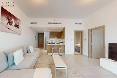 a living room with a couch and a tv at Brand New & Modern 1BR Apartment in Dubai