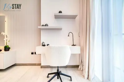 a white office with a chair and a desk at Luxurious Spacious Studio in Dubai