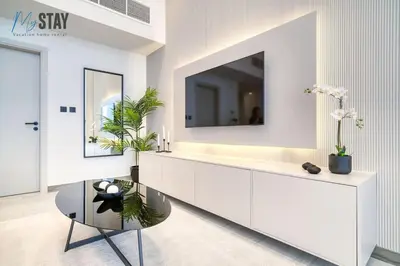 a living room with a tv on a white cabinet at Luxurious Spacious Studio in Dubai