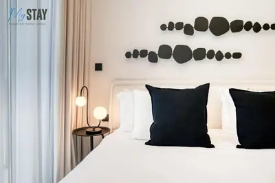 a bedroom with a white bed with black pillows at Luxurious Spacious Studio in Dubai